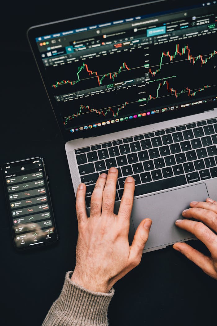 man trading with laptop and phone